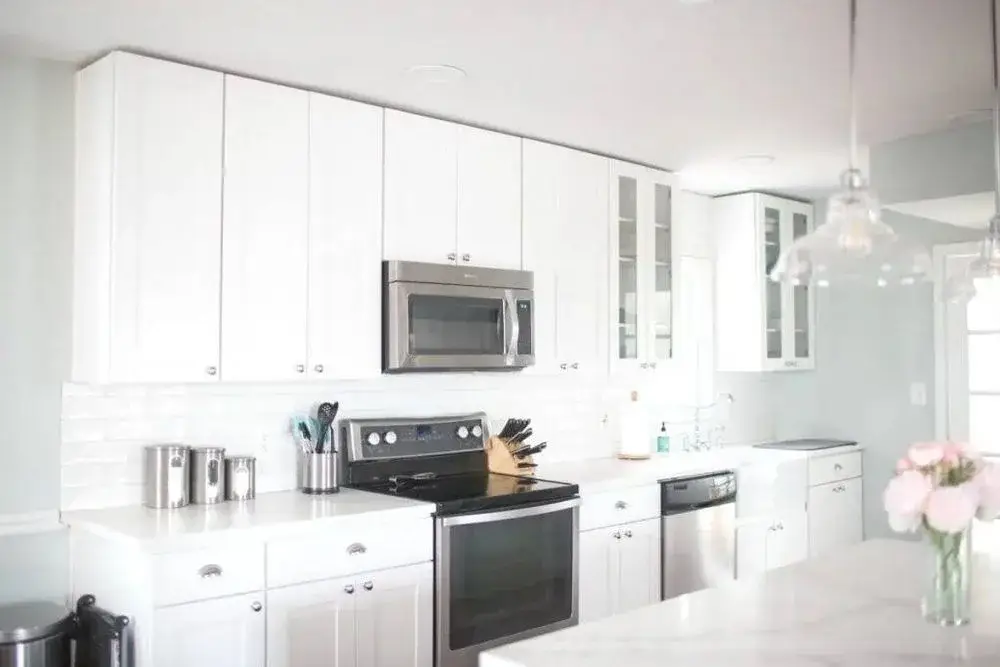 Bright white kitchen with subway tile backsplash and stainless steel appliances after a Standard Cleaning service